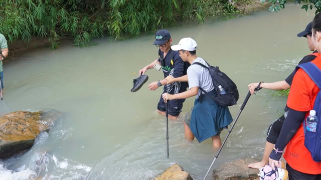 Hướng dẫn vi&ecirc;n hỗ trợ kh&aacute;ch đi qua suối